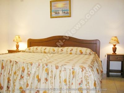 apartment caprice mauritius bedroom view
Caprice Apartment bedroom view. There is a double bed with a yellow, red and blue bedspread. There are two bedside tables, one on either side of the bed, with a lamp on both of them. 
Keywords: Caprice Apartment, bedroom, double bed, bedside tables, lamps,