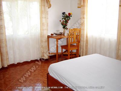 guest house les palmiers chamarel mauritius double bedroom view
View of Les Palmiers Chamarel guesthouse double bedroom. The room has a double bed, a dressing table with a small arrangement of flowers on it, and chair.
Keywords: Les Palmiers Chamarel guesthouse, double room, dressing table, chair, flowers