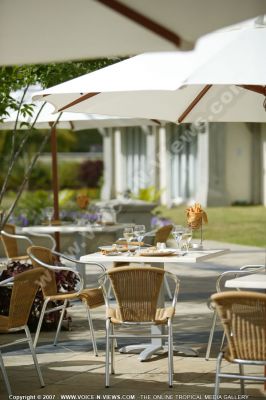 5 star hotel le suffren  and marina hotel terrace
At the 5*Suffren and Marina Hotel, guests can enjoy their meals out in the open on the terrace. There are tables and chairs set under umbrellas. The tables are set with plates, cutlery, glasses, napkin holders and napkins. 
Keywords: 5*hotel, terrace, tables, chairs, meals, umbrellas, plates, cutlery, glasses, napkins, holders