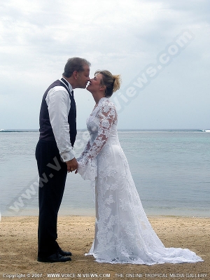 movenpick resort and spa mauritius just married couple kissing on the beach
