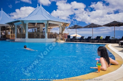 pearle beach resort & spa mauritius guest having cocktail in the swimming pool
