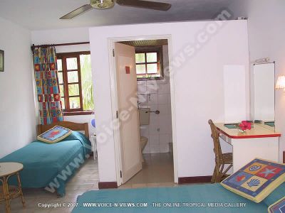budget guesthouse pointe d'esny mauritius ref 165 double room view
Budget Guesthouse Pointe d'Esny Mauritius Ref 165 view of double room. This room has two single beds in it. It also has its own bathroom. There are two tables in the room; one in the centre of the room and one, a dressing table, is near the bathroom. There is an overhead fan in the room.
Keywords: Noix de Coco, double, room, beds, bathroom, tables, chair, fan