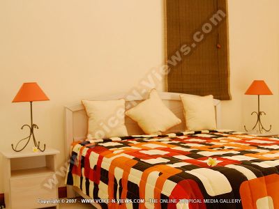 villa four heavens mauritius double room view
Four Heavens Villa double bedroom. The room is situated on the first floor of the villa and is decorated in red, orange, white and brown. On either side of the bed is a bedside table with a lamp on each. 
Keywords: Four Heavens Villa, double bedroom, red, white, orange, brown, bedside tables, lamps
